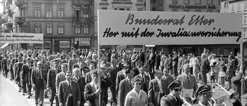 Labour Day Parade: March of musicians under the banner 'Federal Councillor Etter: We Demand Disability Insurance', 1957, source: Sozialarchiv, Zurich.
