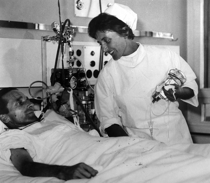 Krankenschwester am Bett eines Patienten.